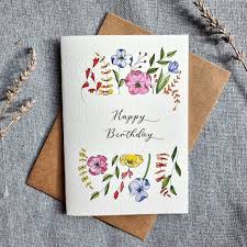 A beautiful handmade greeting card with pressed dried flowers and a "Happy Birthday" message.