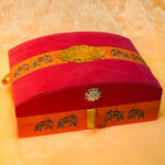 A luxurious deep red velvet gift box with a gold ribbon, recommended for Evarima jewelry.